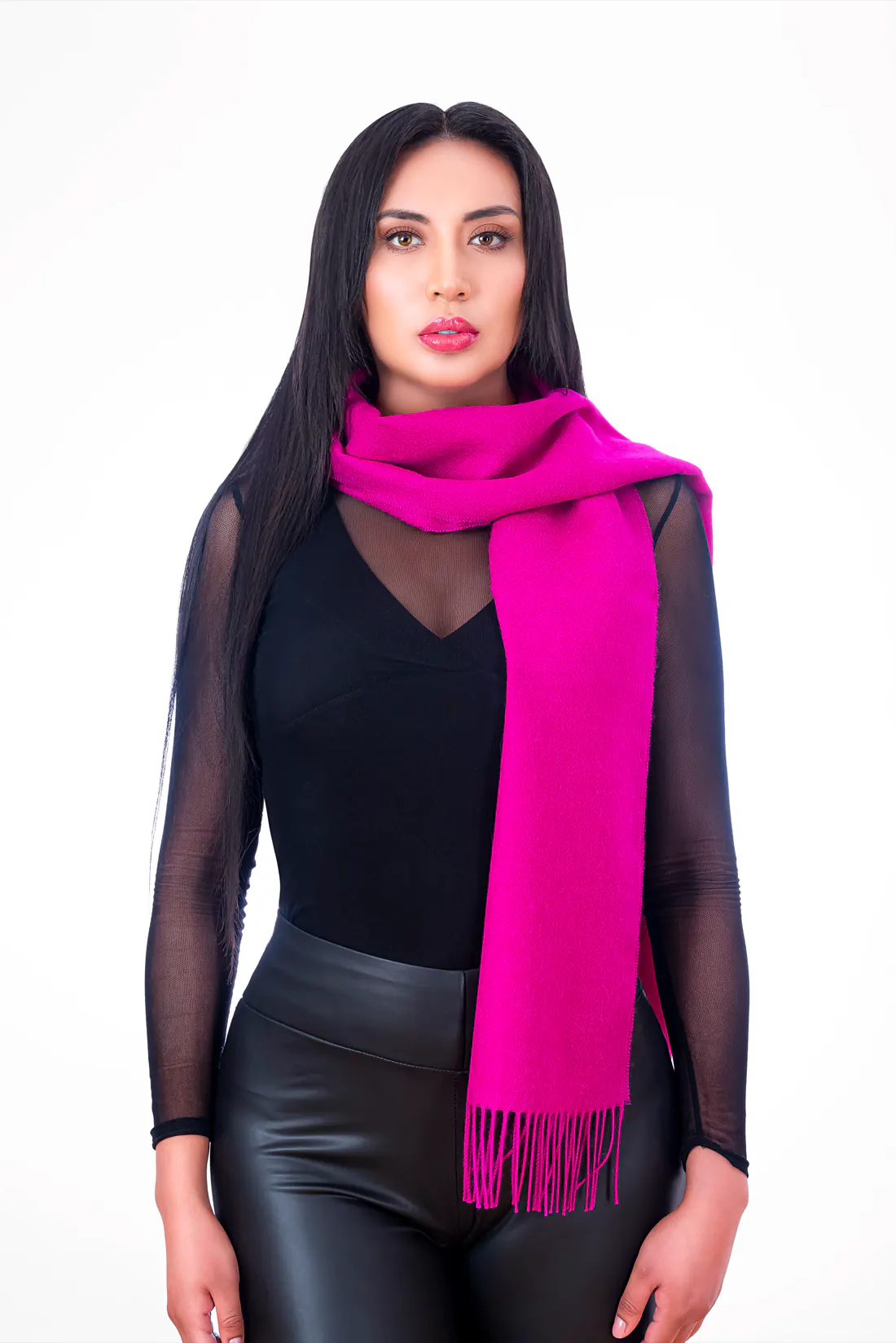 Modelo con una bufanda fucsia con flecos llevada al hombro