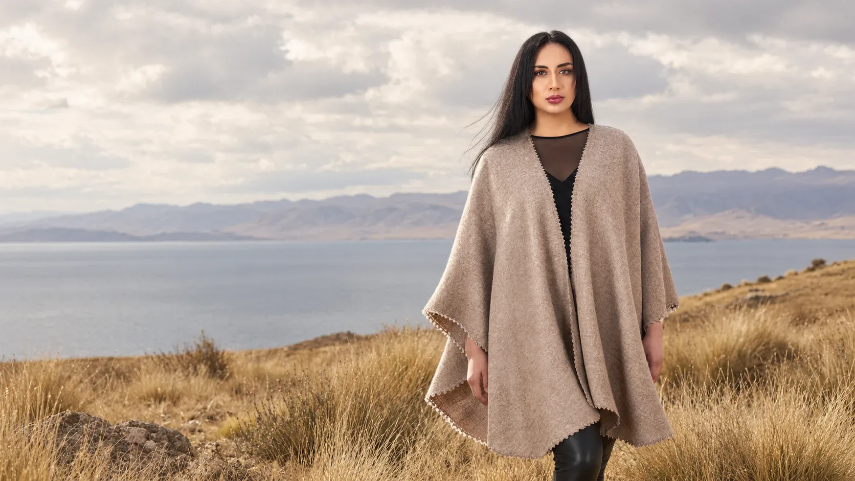 Modelo con una ruana beige de alpaca frente al lago, en el altiplano